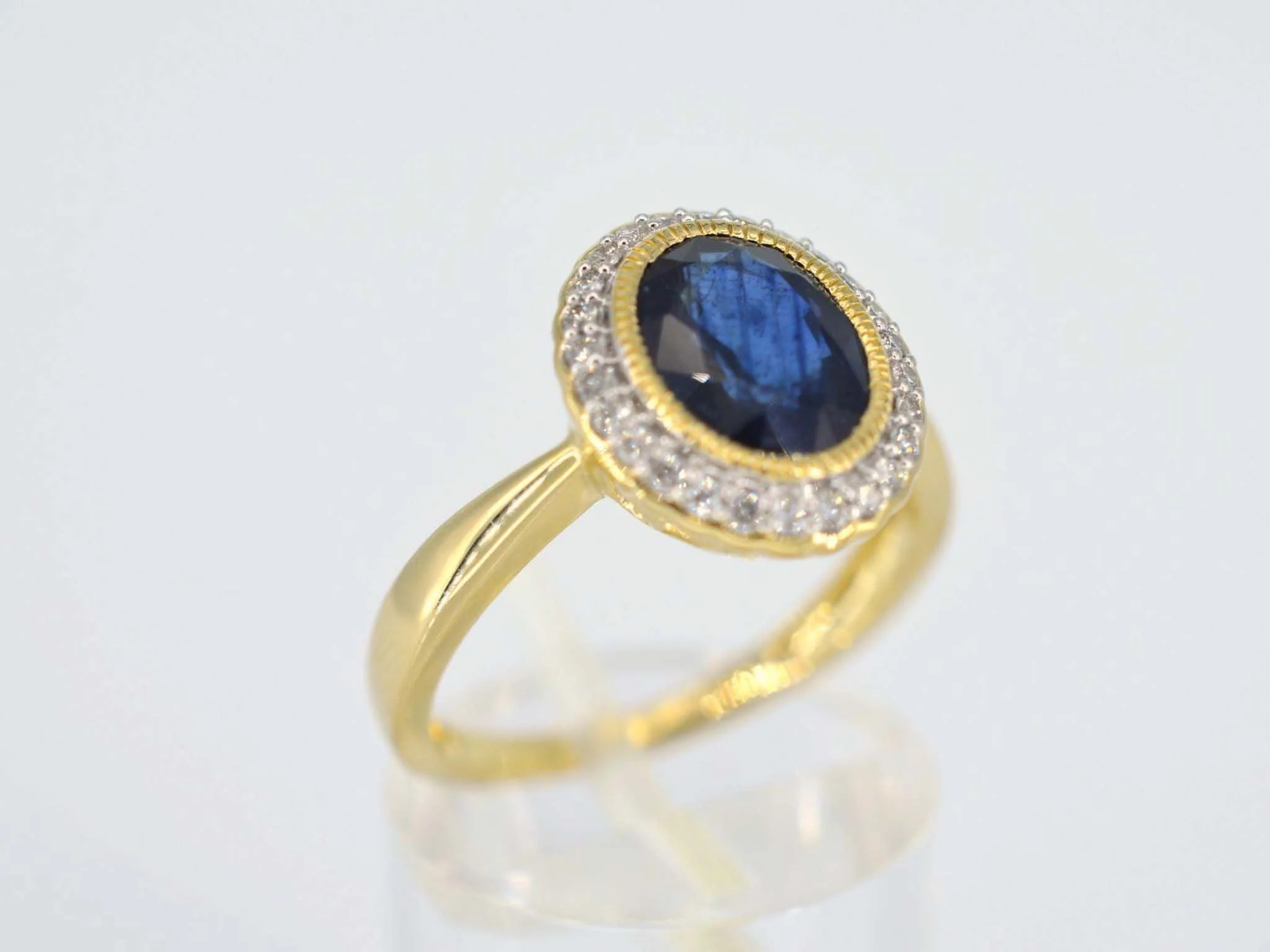 Gold entourage ring with diamonds and sapphire - Image 3